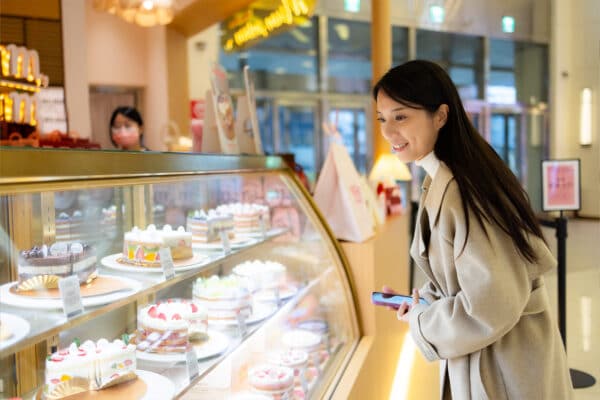 woman looking at pastries in bakery